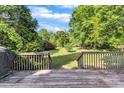 Spacious backyard with lush greenery and a wooden deck, ideal for outdoor entertaining at 8113 Huskfield Ct, Apex, NC 27539