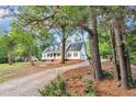 Beautiful home surrounded by mature trees, featuring a long driveway and attached garage at 8113 Huskfield Ct, Apex, NC 27539