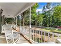 Inviting front porch with white rocking chairs, perfect for relaxing and enjoying the view at 8113 Huskfield Ct, Apex, NC 27539