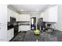 Modern kitchen featuring white cabinets, granite countertops, and stainless steel appliances at 870 Live Oak Ln, Nashville, NC 27856