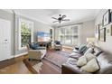 Cozy living room with hardwood floors, a ceiling fan, and plenty of natural light at 106 Bluefield Rd, Chapel Hill, NC 27517