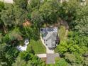 Aerial view showcasing a landscaped yard, patio and fire pit, and lush greenery surrounding the property at 120 Harmony Hill Ln, Cary, NC 27513