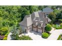 Luxury home with a large driveway, three-car garage, and lush landscaping under a sunny sky at 12317 Richmond Run Dr, Raleigh, NC 27614