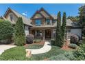 Charming home featuring manicured landscaping and an elegant, arched entryway with double wooden doors at 12317 Richmond Run Dr, Raleigh, NC 27614