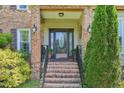 Brick stairway leading up to the front door with decorative glass and mature landscaping at 1315 Brigham Rd, Chapel Hill, NC 27517