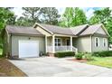 A well maintained home with an attached garage, an expansive driveway and verdant landscaping at 1980 Ferbow St, Creedmoor, NC 27522