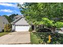 View of the exterior of the home featuring attractive landscaping and a tree in the front yard at 2037 Summer Shire Way, Raleigh, NC 27604
