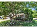 Exterior view of home showcasing covered porch, large tree, and lush landscaping in the front yard at 2037 Summer Shire Way, Raleigh, NC 27604