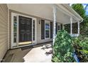 Close-up of front porch featuring black door, white trim, and manicured landscaping at 2037 Summer Shire Way, Raleigh, NC 27604