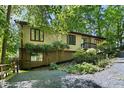 Exterior view of home featuring gravel driveway and lush green foliage all around at 205 Bruton Dr, Chapel Hill, NC 27516