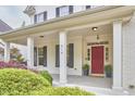 Inviting covered front porch with stately columns and a vibrant red front door at 210 Bennington Pkwy, Durham, NC 27713