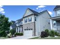 Beautifully constructed home with a brick and siding facade, complemented by well-maintained landscaping and a driveway at 232 Hensley Hill Pl, Holly Springs, NC 27540