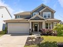 Charming two-story home featuring a gray facade, covered porch, two-car garage, and well-maintained landscaping at 325 Avery Glenn Way, Fuquay Varina, NC 27526