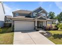 Charming two-story home featuring a gray facade, covered porch, two-car garage, and well-maintained landscaping at 325 Avery Glenn Way, Fuquay Varina, NC 27526