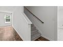 Bright stairway with neutral carpet, wood railing, and a window at the landing at 3816 Mike Levi Ct, Raleigh, NC 27610