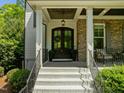 Elegant front entrance with a beautiful wood door, stone accents, and stylish lighting at 3913 Orchard Point Ct, Apex, NC 27539