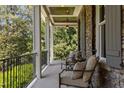 Inviting front porch with comfortable seating, stone columns, and a serene outdoor ambiance at 3913 Orchard Point Ct, Apex, NC 27539