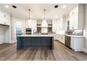Spacious kitchen boasts an island, modern appliances, and pristine white cabinetry providing ample storage at 4009 Yates Mill Pond Rd, Raleigh, NC 27606