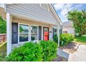 Eye-catching single-Gathering home with a bright red door, tidy landscaping, and a covered porch at 4114 Sudbury Rd, Durham, NC 27704