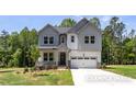 Inviting two-story home with a charming front porch and an attached two-car garage, surrounded by mature trees at 452 Golden Dragonfly St, Wake Forest, NC 27587