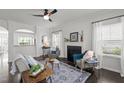 Bright living room with a fireplace, hardwood floors, and plenty of natural light from the large windows at 4718 Sleepy Falls Run, Knightdale, NC 27545