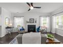 Stylish living room features modern ceiling fan, large windows, dark hardwood floors, and neutral decor at 4718 Sleepy Falls Run, Knightdale, NC 27545