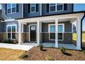 View of the home's covered front porch with white columns, gray siding and brick accents at 50 Rosewood Ln, Youngsville, NC 27596