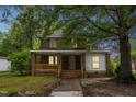 Charming two-story brick home with a welcoming front porch and mature trees at 500 Cokey Rd, Rocky Mount, NC 27801