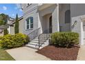 Home's entrance with decorative stairs leading up to the arched doorway, surrounded by manicured landscaping at 5145 Landguard Dr, Raleigh, NC 27613