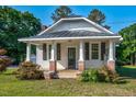 Charming home showcasing a metal roof, covered porch with white columns, and lush landscaping at 5299 Momeyer Way, Nashville, NC 27856
