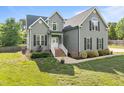 Beautiful two-story home with a well-manicured lawn, brick accents, and a welcoming front porch at 6200 Oliver Creek Pkwy, Holly Springs, NC 27540