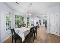 Sunlit dining room featuring a wood table, chairs and an elegant chandelier at 6612 Rossford Ln, Durham, NC 27713