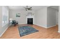 Bright living room featuring a fireplace, ceiling fan, wood-look flooring, and neutral paint at 6921 Peppermill Way, Rocky Mount, NC 27804