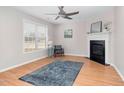 Bright living room featuring a fireplace, ceiling fan, wood-look flooring, and neutral paint at 6921 Peppermill Way, Rocky Mount, NC 27804