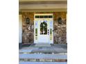 Elegant front door with sidelights, stone accents, and stylish lighting fixtures, creating a welcoming entrance at 7501 Tipsy Sq, Wake Forest, NC 27587