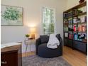 Cozy home office with a comfortable chair, built-in bookshelves, and natural light streaming through the window at 7501 Tipsy Sq, Wake Forest, NC 27587