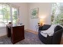 Bright home office featuring a wooden desk, comfortable chair, and large windows offering scenic outdoor views at 7501 Tipsy Sq, Wake Forest, NC 27587