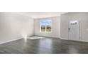 Bright living room features wood floors, a large window, and a white door at 828 Old Tarboro Rd, Wendell, NC 27591