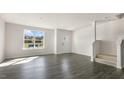 Bright living room with hardwood floors, large window, and staircase at 834 Old Tarboro Rd, Wendell, NC 27591