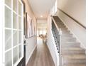 Inviting entryway featuring hardwood floors, a staircase, and modern decor at 836 Ottawa Dr, Garner, NC 27529