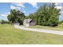 Well-manicured lawn leading to two-story home with stone and shingle exterior and detached garage at 91 Carsons Creek Trl, Wendell, NC 27591