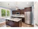 Modern kitchen featuring granite countertops, stainless steel appliances, and custom wood cabinets at 91 Carsons Creek Trl, Wendell, NC 27591