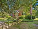 Traditional brick townhouse with manicured landscaping and mature trees offers a welcoming curb appeal at 945 St Marys St, Raleigh, NC 27605
