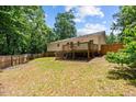 Spacious backyard featuring a wooden deck and fenced perimeter, perfect for outdoor activities at 1004 Candlewood Cir, Siler City, NC 27344
