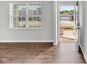 Bright living room featuring hardwood floors and a view of the neighborhood through a large window at 103 Norris Creek Dr, Clayton, NC 27527