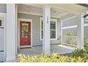 Welcoming front porch with a vibrant red door, classic white columns, and well-maintained landscaping at 120 Chapel Run Way, Chapel Hill, NC 27517