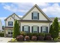 Charming two-story home with inviting front porch and well-manicured landscaping at 121 Martingale Dr, Holly Springs, NC 27540