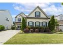 Beautiful two-story home featuring a long driveway and a well maintained lawn at 121 Martingale Dr, Holly Springs, NC 27540
