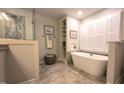 Modern bathroom with a soaking tub, tiled floors, and a glass-enclosed shower at 125 Amesbury Ln, Cary, NC 27511