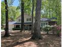 Traditional-style home nestled among mature trees with a spacious, landscaped front yard at 125 Amesbury Ln, Cary, NC 27511